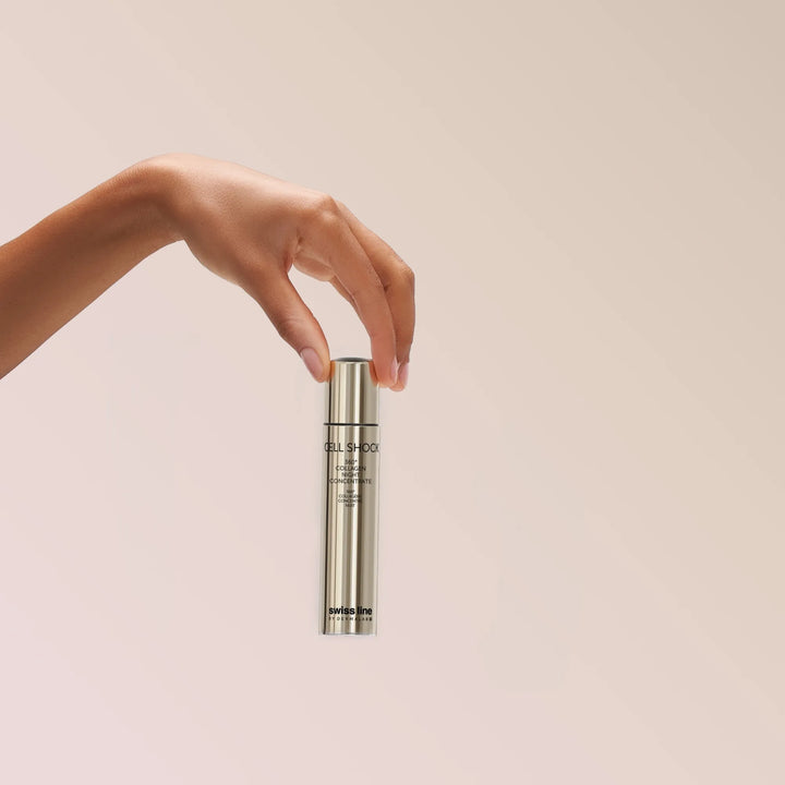 Hand holding a skincare bottle against a beige background