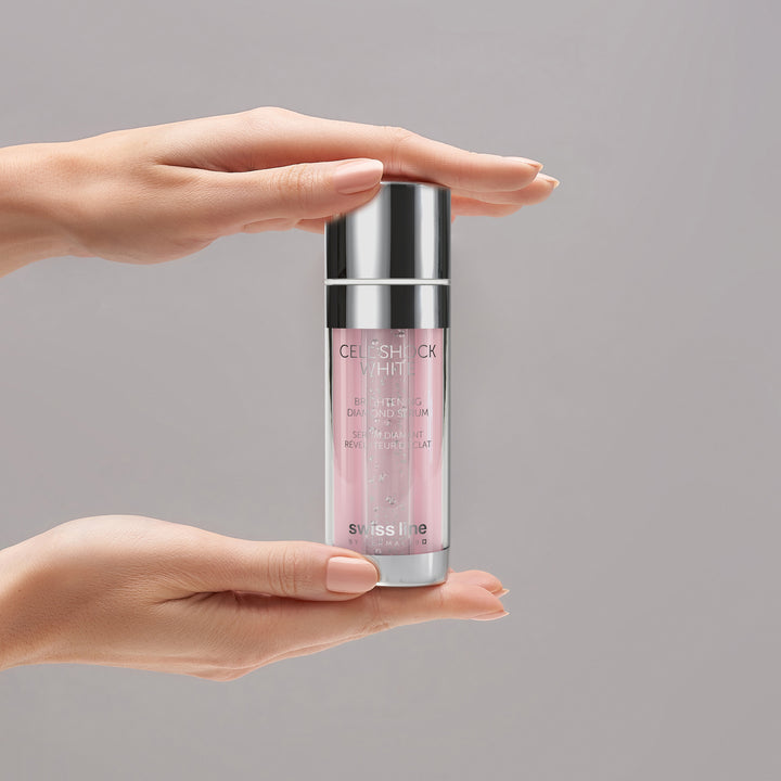 Person holding a skincare product with 'swiss line' branding against a gray background