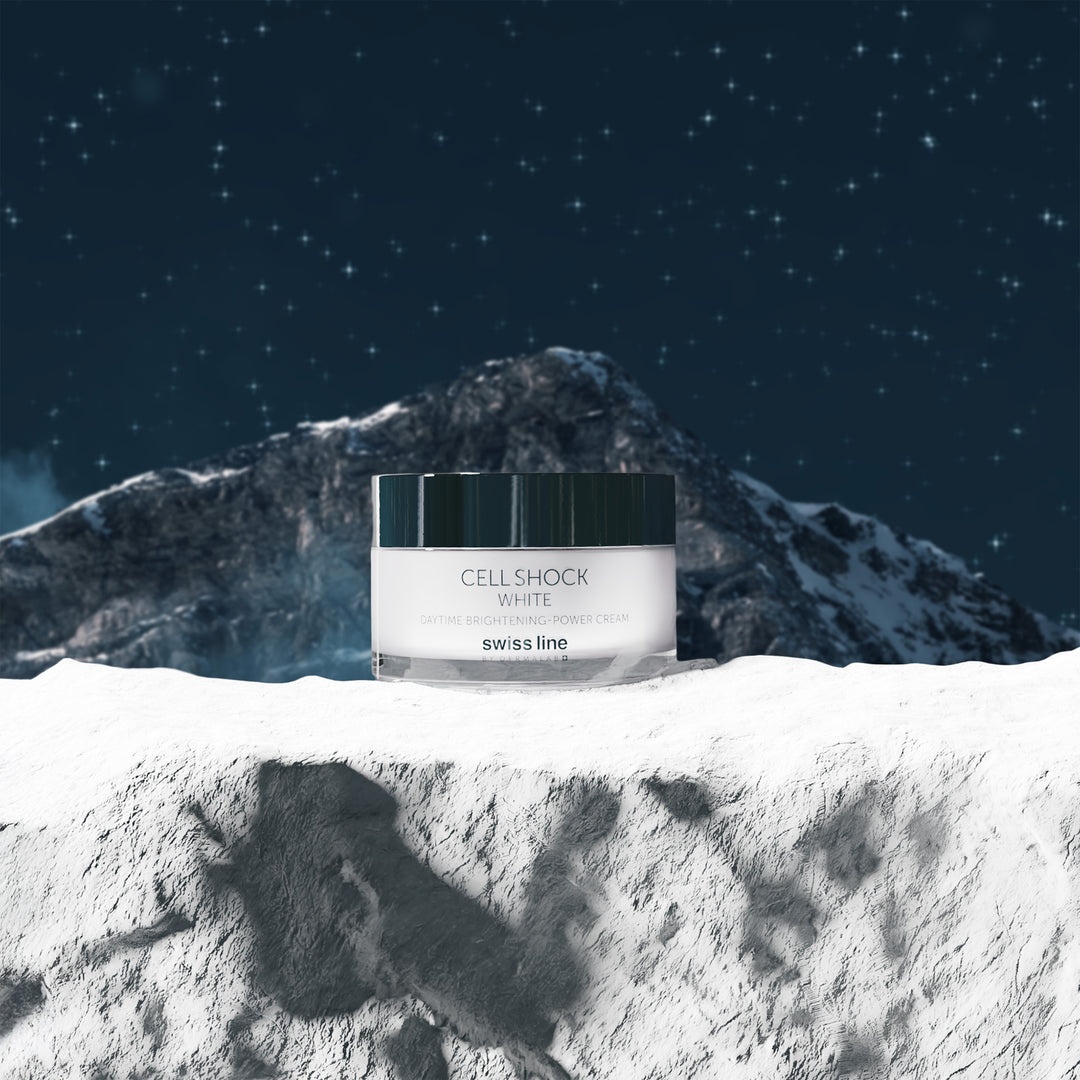 Cosmetic jar labeled 'CellShock White' by Swiss Line on a snowy mountain background