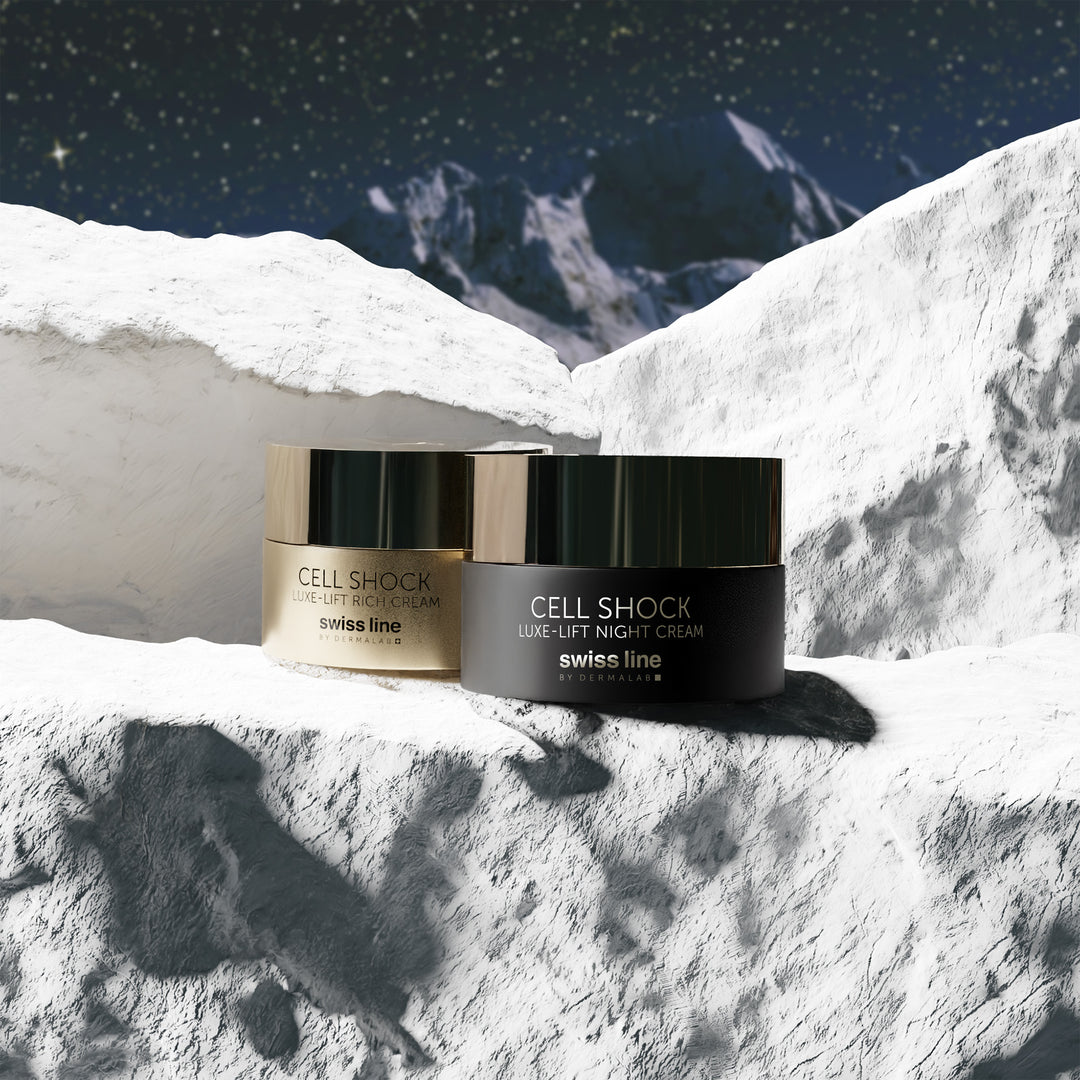 Two jars of swiss line Cell Shock Luxe-Lift Night Cream on a snowy mountain background