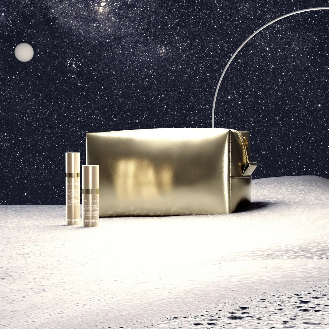 Gold cosmetic bag and bottles on a moon-like surface with a starry night sky.